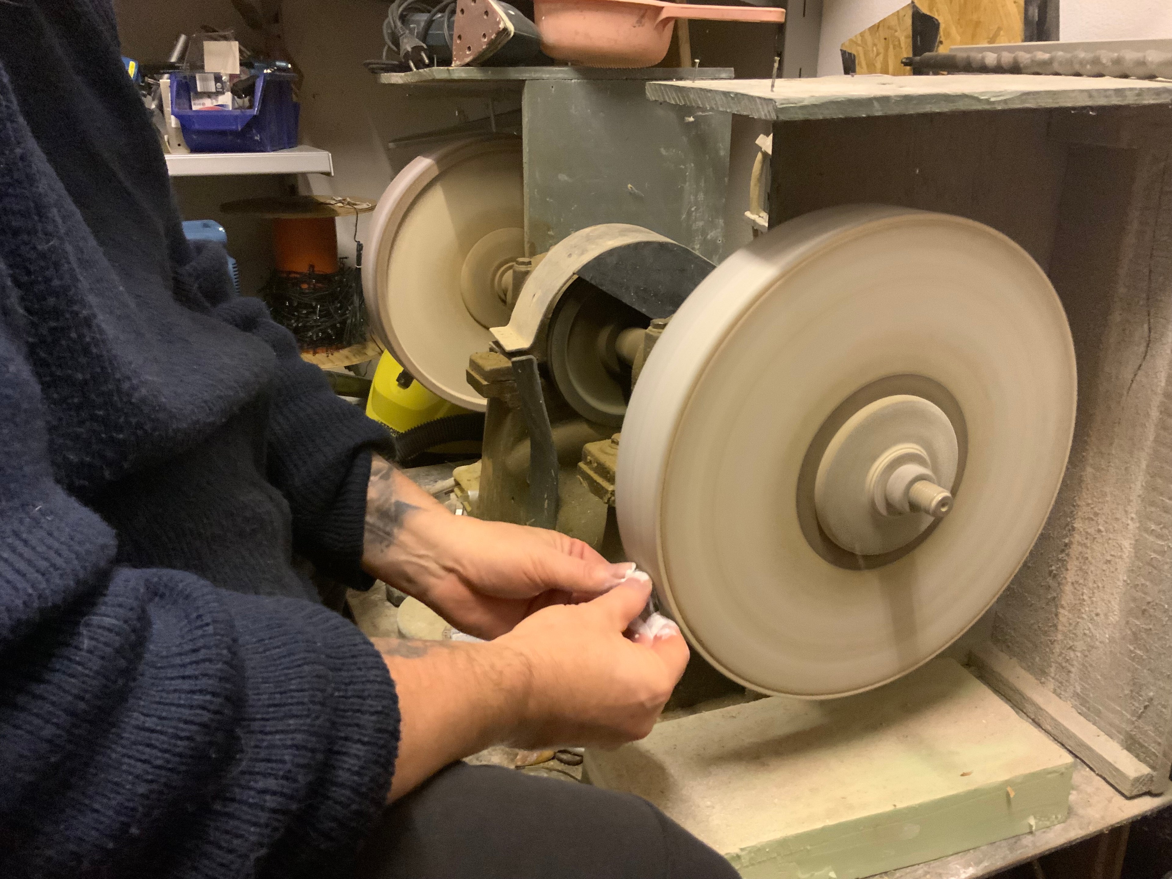 Klaus Rothfuchs schleift einen Mondstein in seiner eigenen Produktion