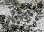 Eine Vielzahl an Rohdiamant Anhänger auf einem Holz liegend