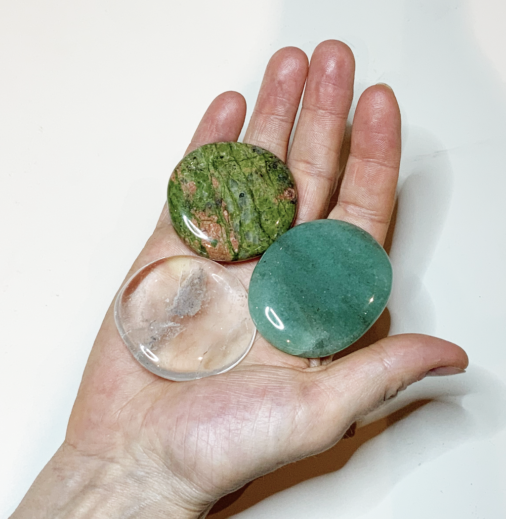 Mustersteine Bergkristall, Aventurin und Epidot Unakit auf der Innenseite einer Hand liegend
