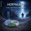 Mystische Gestalt in Sternenregen bewegt sich auf die Edelsteine Budstone, Bergkristall und Angelit zu, Text "Hoffnung, Licht, Vertrauen, Neubeginn"