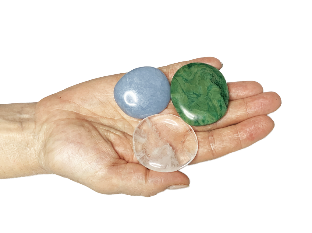 Die Scheibensteine Budstone, Angelit und Bergkristall auf einer Hand liegend